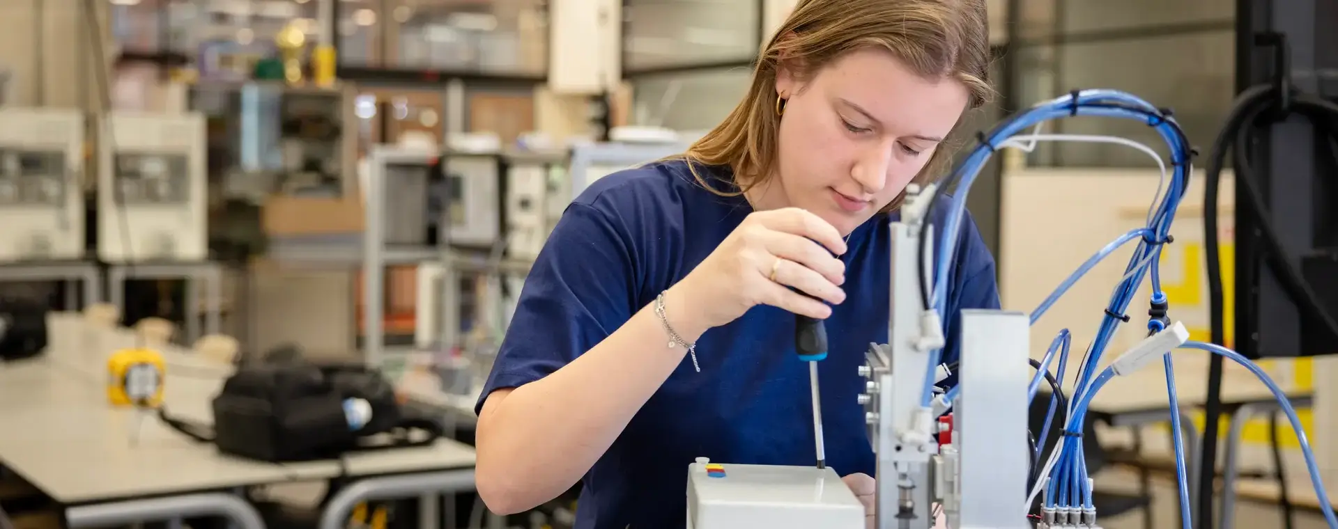 Student inspecteert apparaat in praktijklokaal