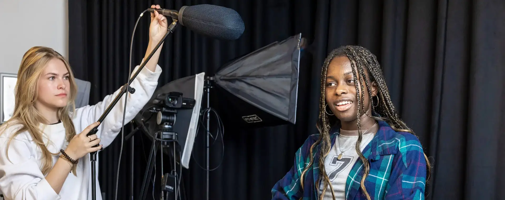 Studenten AV-technicus in een talkshowsetting met boom mic. 