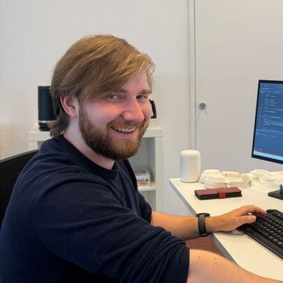 ICT-student Tom achter toetsenbord en twee beeldschermen