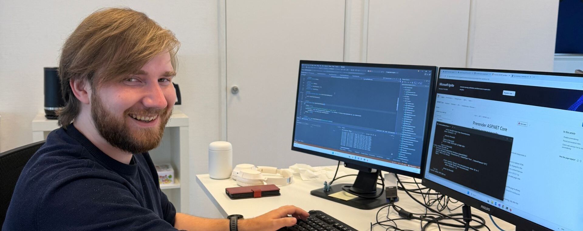 ICT-student Tom achter toetsenbord en twee beeldschermen