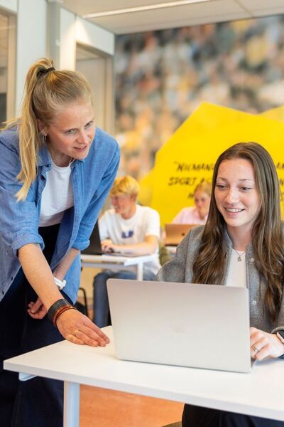 Docent helpt student in klaslokaal