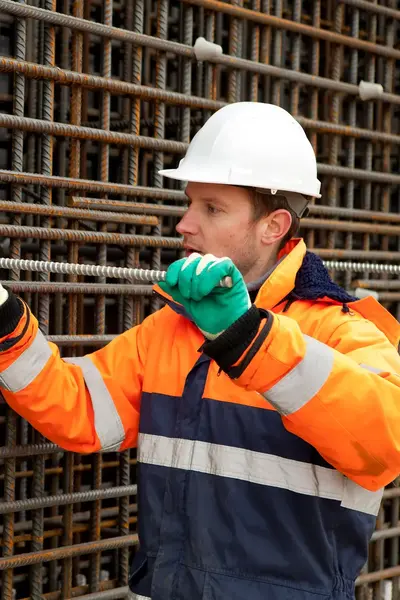 Constructiewerker met bouwhelm werkt aan metalen constructie