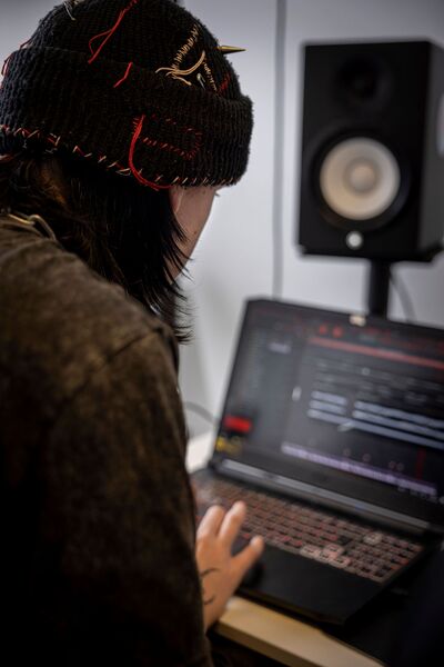 Student Music Production aan het werk achter laptop