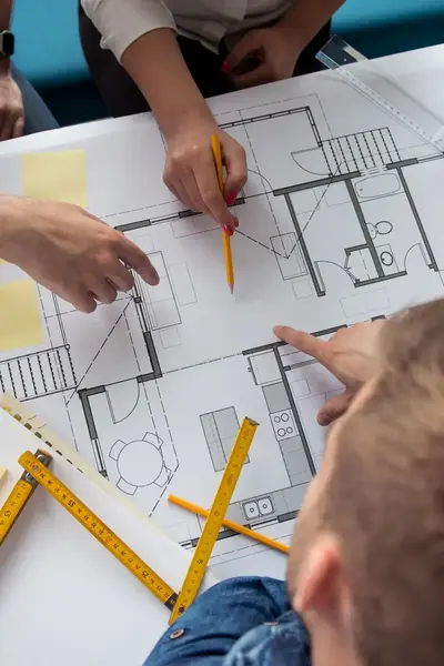 Twee mensen werken aan een bouwtekening