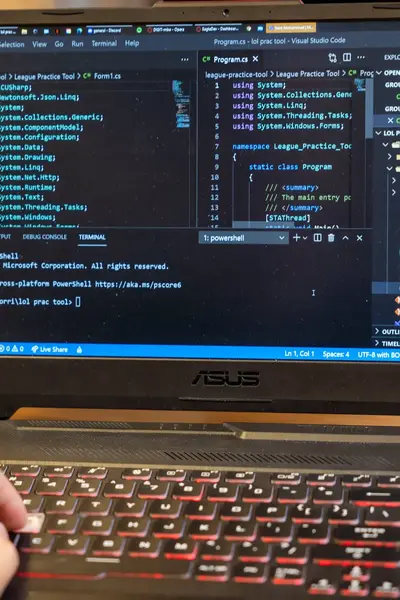 Laptop met programmeeromgeving en hand op het toetsenbord