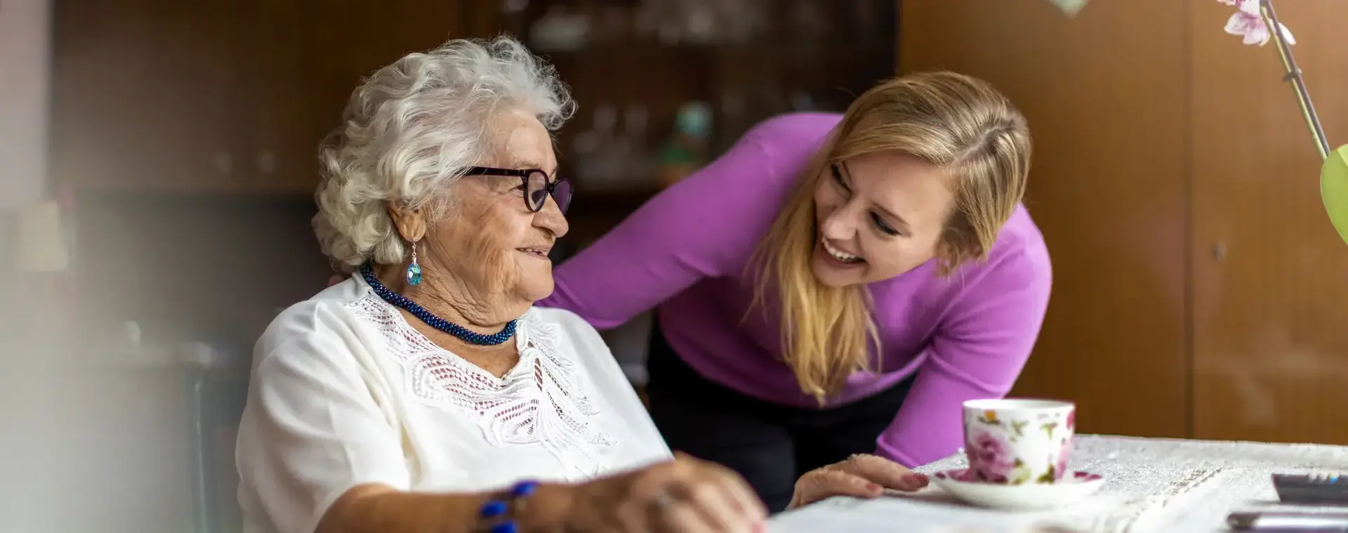 Jonge dame houdt oude dame gezelschap.