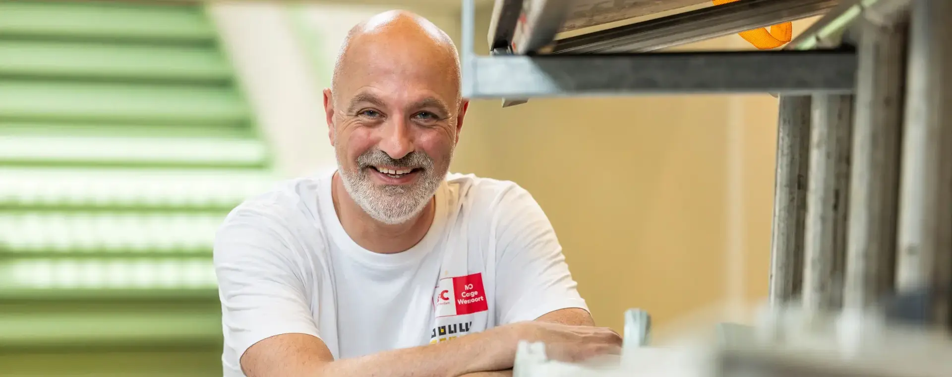 Docent van de bouwacademie poseert lachend voor de camera