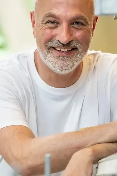 Docent van de bouwacademie poseert lachend voor de camera