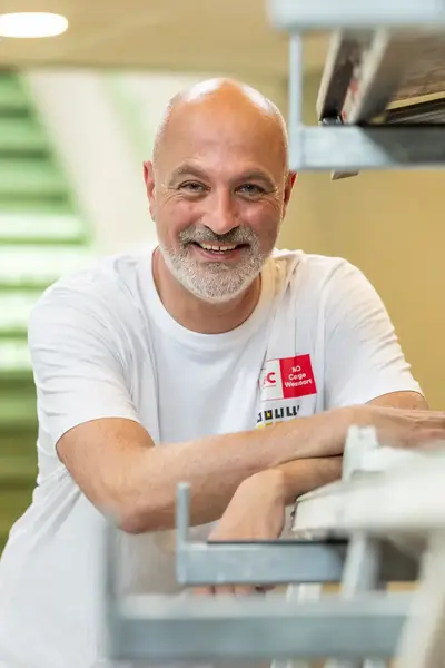 Docent van de bouwacademie poseert lachend voor de camera