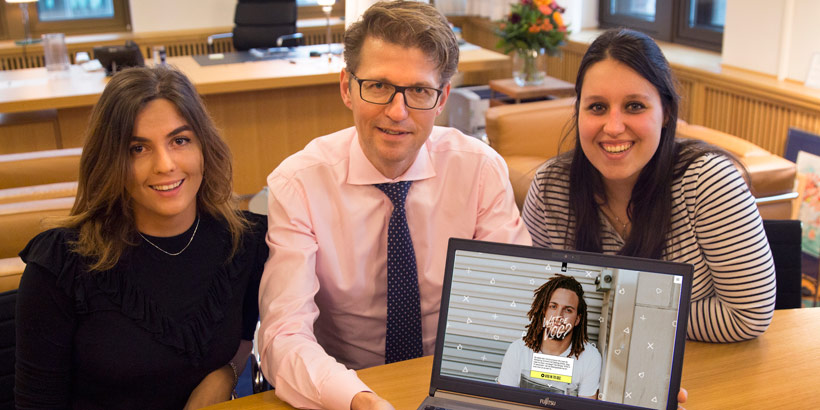Minister Dekker gaat in gesprek met twee studenten over de Verklaring Omtrent het Gedrag